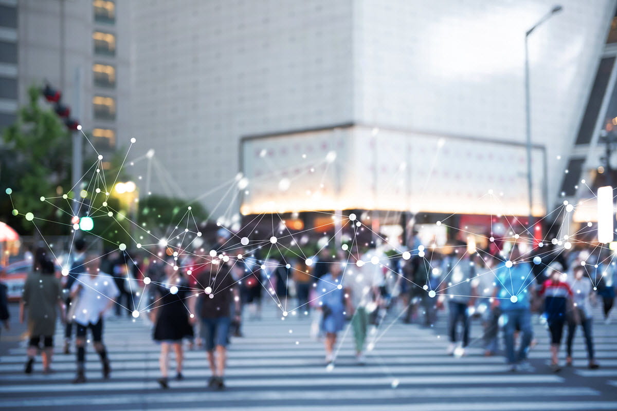 City with people walking on streets with virtual dotted lines illustrating the connected technology